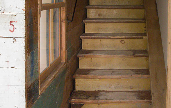 L’escalier qui mène à l’étage de la meunerie et aux carrés à grains